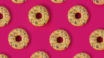 padrão criativo festivo de filas de donuts em fundo rosa foto