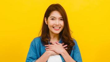 mulher asiática com expressão positiva sobre fundo amarelo. foto