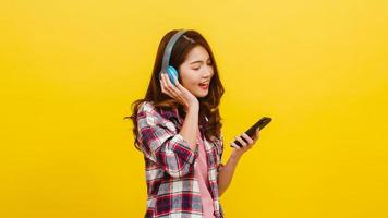 senhora asiática usando fones de ouvido, ouvindo música no smartphone. foto