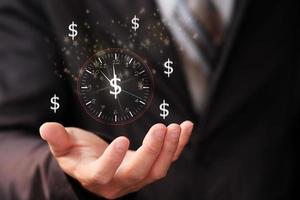 empresário segurando um relógio de parede e tempo de negócios é dinheiro foto