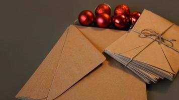 composição de natal. envelopes artesanais e bolas vermelhas foto