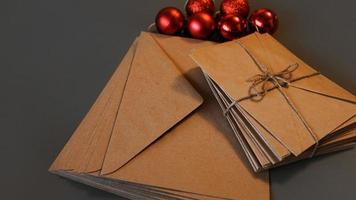 composição de natal. envelopes artesanais e bolas vermelhas foto