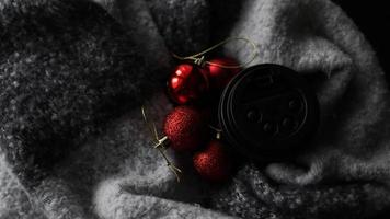 xícara de café com bolas vermelhas de natal em um fundo cinza foto