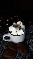 caneca com marshmallows e biscoitos de chocolate foto