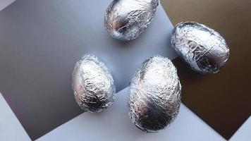 ovos em papel alumínio em fundo prata. conceito de páscoa foto
