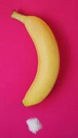 banana e açúcar em um fundo rosa foto