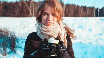 bela jovem segurando uma xícara de café com marshmallow foto