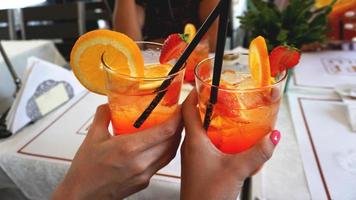 jovem casal alegre tomando coquetel aperol spritz em um café foto