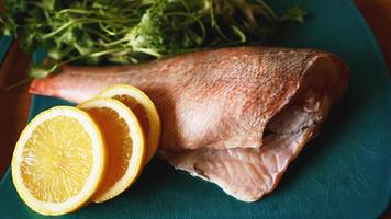 peixe fresco, filetes de bacalhau crus com adição de ervas e limão foto