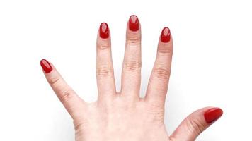 linda mão feminina com manicure e unha vermelhas foto