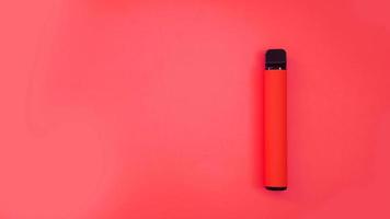 cigarro eletrônico descartável vermelho em fundo vermelho brilhante foto