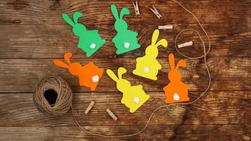 coelhinhos da Páscoa feitos de papel em um fundo de madeira. crie uma decoração