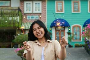 alegre jovem ásia mulher segurando diamante para comemoro Novo ano véspera com jardim festa em pé sobre colorida vintage casa Jardim foto