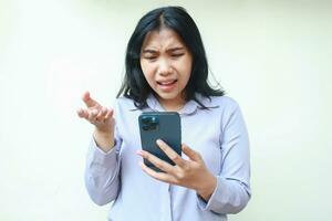 desapontado bonita ásia jovem ocupado mulher usando mão telefone com levantando mão aberto Palma vestem formal terno, isolado em branco foto