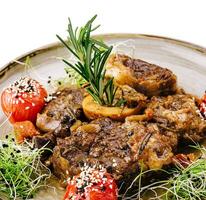 grelhado churrasco bifes com fresco ervas e tomates foto