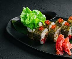 Sushi rolos servido em pedra ardósia vermelho caviar foto