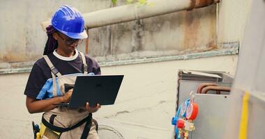 com experiência engenheiro trabalhando em externo hvac sistema, segurando computador portátil. meticuloso Wireman otimizando ao ar livre condensador desempenho, garantindo isto opera às máximo capacidade foto