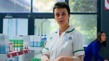 retrato do alegre farmacêutico dentro farmacêutico preparando medicamentos ordem para cliente. sorridente cuidados de saúde especialista dentro farmácia colocação cardiovascular pílulas dentro compras saco para cliente foto