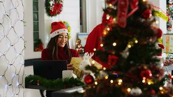 ásia trabalhador recebendo presentes a partir de generoso colega agindo Como santa dentro natal decorado escritório. empregado vestindo festivo traje surpreendente colegas de trabalho com apresenta durante inverno feriado estação foto