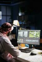 árabe masculino cineasta trabalhando com cenas e som, edição uma Novo projeto, e produzindo uma filme montagem. uma fechar-se do uma muçulmano homem trabalhando em pós-produção Programas em uma computador. foto