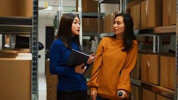 fêmea empregado dentro muletas fazendo qualidade ao controle com pequeno o negócio proprietário perto armazém prateleiras. jovem mulher com fisica problema trabalhando com computador portátil para fornecem cadeia Produção. foto