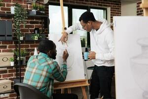 dois africano americano homens amigos desenhando em tela de pintura durante arte aula, desfrutando artístico criativo passatempo junto, gastos livre Tempo Aprendendo para desenhar com lápis. masculino alunos criando obra de arte juntos foto