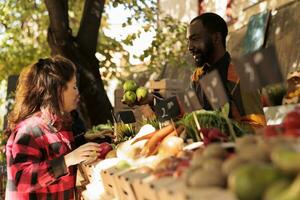 diverso pessoas falando sobre orgânico bio produtos às agricultores mercado, vários natural agricultura produzir. jovem homem e mulher olhando às localmente crescido fresco eco frutas e legumes. foto