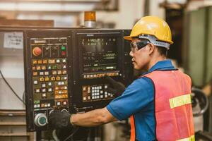 ásia trabalhador trabalhos com automatizado digital torno cnc metal máquina. engenheiro configuração operar programação moagem máquina dentro fábrica. foto