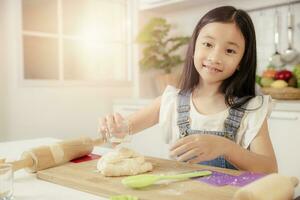 criança menina retrato feliz sorridente jogando cozinhando padaria Comida às casa cozinha feriado atividade foto