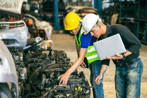 Senior engenheiro equipe Verifica inventário loja velho usava auto poupar parte motor engrenagem parte Lista para venda reciclar dentro reparar carro garagem mercado foto