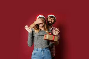 elegante casal dentro amor posando em vermelho fundo dentro elegante elegante roupa. Novo ano humor foto