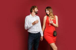 elegante casal dentro amor posando em vermelho fundo dentro elegante elegante roupa. Novo ano humor foto