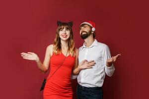 elegante casal dentro amor posando em vermelho fundo dentro elegante elegante roupa. Novo ano humor foto