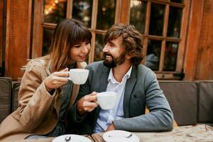 romântico momentos do elegante casal dentro amor sentado dentro uma cafeteria, bebendo café, tendo uma conversação e desfrutando a Tempo gastar com cada outro. foto