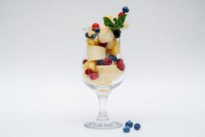 copo de salada de frutas isolado no fundo branco foto