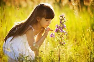 menina toca em uma flor silvestre foto