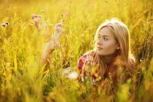 garota feliz em um campo de grama e flores foto