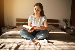 menina senta e lê um livro foto