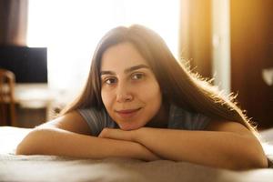 menina deitada em casa na cama foto