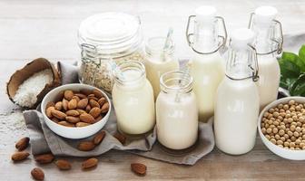 tipos alternativos de leites veganos em garrafas de vidro foto