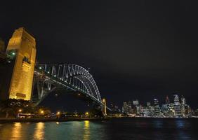 famosa ponte do porto de sydney e marcos do horizonte cbd na austrália à noite foto
