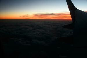 misterioso pôr do sol com nuvens a partir de a avião janela com foto