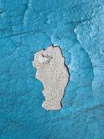 velho concreto parede coberto com azul pintura com rachaduras Como uma fundo superfície foto