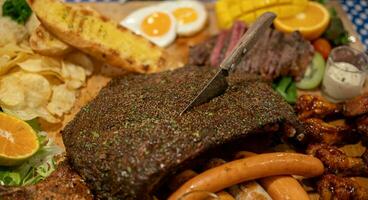 grelhado sortido carne com batata e mergulho molhos em de madeira prato. foto