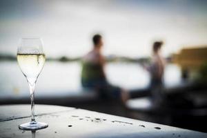 taça de espumante vinho espumante em moderno bar ao ar livre ao pôr do sol foto