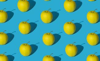 na moda fruta padronizar fez do amarelo maçãs em luz pastel azul fundo. mínimo layout. natureza verão conceito. foto