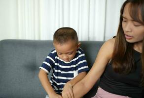 ásia Garoto massageando mãe ombros e braços foto