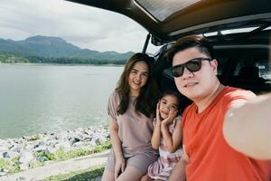 verão pausa feliz família tendo Diversão enquanto levando uma selfie Câmera. a conceito do família em período de férias e viagem. foto