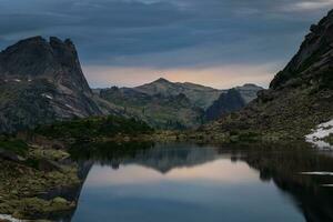 deslumbrante alvorecer em a lago. montanha espíritos lago dentro ergaki em a verão manhã entre a taiga pedras com dramático céu e árvore montanha panorama. ergaki natureza parque dentro a montanhas do Sibéria. foto