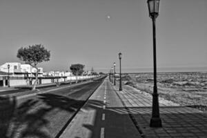 Largo asfalto estrada em a espanhol canário ilha fuerteventura com Palma árvores foto